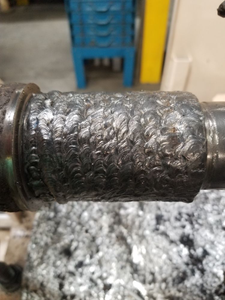Weld material added to a shaft so it can be turned back down to size